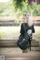 A woman sitting on a bench with a backpack.