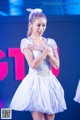 A woman in a white dress dancing on a stage.