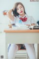 A woman sitting at a desk with her head in her hands.