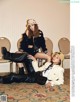 A couple of women sitting on top of a carpeted floor.