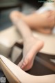 A woman is sitting in a chair with her feet up.