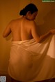 A woman wrapped in a white towel in a bathroom.