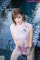 A woman in a pink dress sitting in a pool.