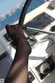 A person's foot on the steering wheel of a boat.