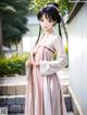 A woman in a pink kimono standing in front of a building.