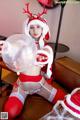 A woman in a santa claus outfit holding a bubble.