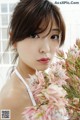 A woman holding a bunch of flowers in her hand.