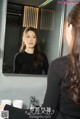 A woman looking at herself in the mirror. 