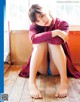 A woman sitting on the floor with her legs crossed.