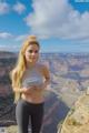 A woman standing on top of a cliff overlooking a canyon.