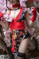 A woman in a red and black kimono posing for a picture.